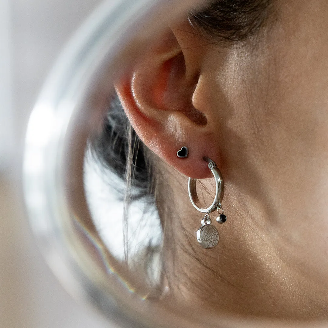 Silver coloured hoop earrings with a coin charm